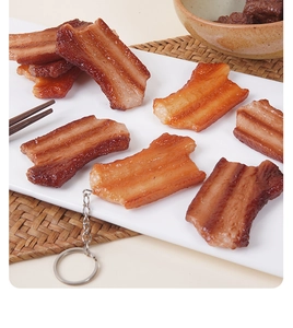 Realistic PVC braised pork belly keychain model on a white plate for food props