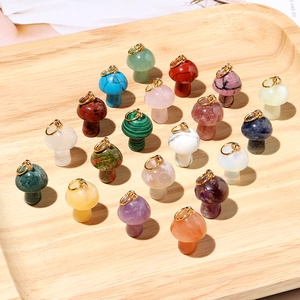 Variety of mini crystal mushroom pendants on a light wood tray with gold metal hooks