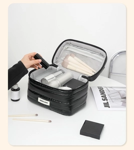 Vista interna della capiente borsa cosmetica in nylon trapuntato con tasche a rete