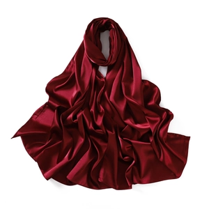 Detail of burgundy satin silk scarf showing smooth lustrous texture and premium drape
