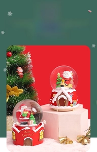 Detail of Christmas music boxes featuring Santa Claus and resin holiday-themed bases