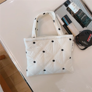 Dettaglio della trama trapuntata e dell'etichetta Simple Wish sulla borsa a pois