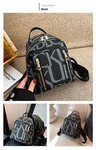 Detail view of a black faux leather backpack with monogram pattern and gold zippers