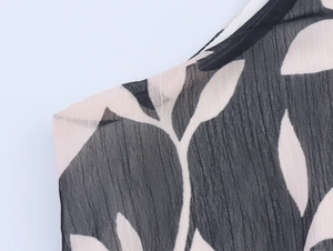 Detail of black and white leaf print on lightweight chiffon fabric with vertical texture