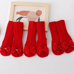 Three pairs of red baby floor socks with striped cotton texture and decorative bows