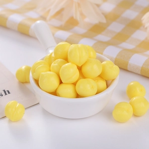 Macro shot of mini yellow TPR peach stress relief toys in a small white ceramic bowl