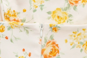 Detail eines unsichtbaren weißen Reißverschlusses und Blumendruck auf einem Kleid