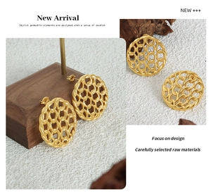 Detail of gold hollow geometric hoop earrings with textured chain link design
