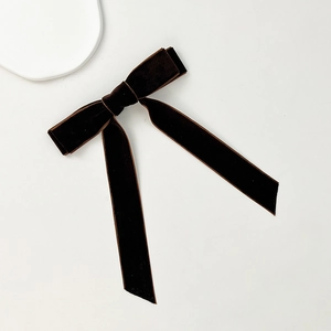 Macro detail of the dark coffee velvet bow hair clip with long elegant streamers