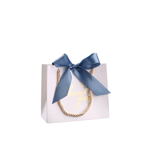 Elegant white wedding candy gift box with blue ribbon bow and gold handles