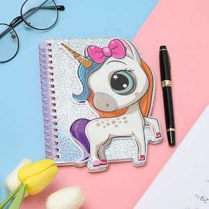 Close-up of unicorn spiral notebook with silver glitter cover and floral decorations