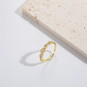 Minimalist adjustable gold open ring with small clear zircons on white stone base