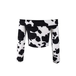 Detail of soft plush texture and black and white cow print on off-shoulder crop top