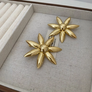 Elegant gold flower earrings with six petals displayed in a gray jewelry storage box