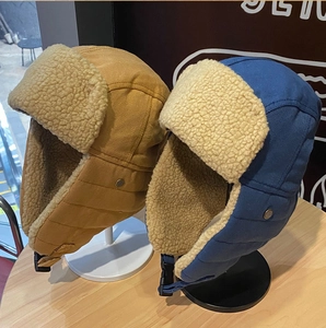 Dettaglio di cappelli da aviatore caldi con fodera in pelliccia sintetica gialla e blu