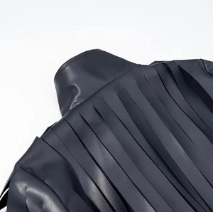 Detailed macro view of stylish fringe design on the back of the dark blue PU leather jacket