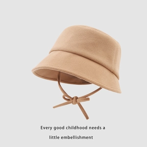 Détail d'un chapeau bob tricoté pour enfants kaki avec lanière réglable à nœud papillon