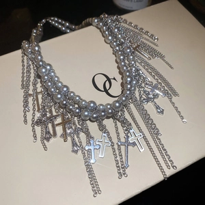 Detailansicht der mehrlagigen grauen Perlenkette mit Kreuzanhängern und Metallfransen