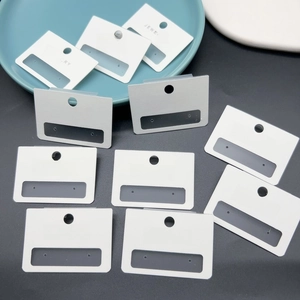Close-up of white jewelry display cards with hanging holes and Jewelry branding text