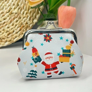 Mini Christmas coin purse with Santa print and metal clasp on warm festive background