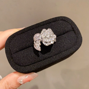 Detailed view of silver rose ring with pave zircon crystals in a black velvet jewelry box