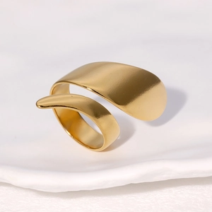 Modern irregular golden wide open ring with smooth flowing design on white background