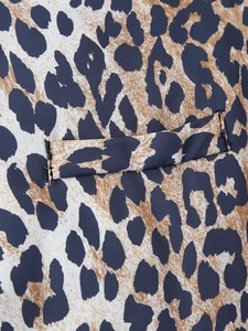 Close-up detail of leopard print fabric with precise stitching and functional pocket design