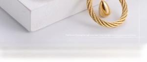 Macro shot of gold-plated woven circle pendant with a smooth teardrop charm details