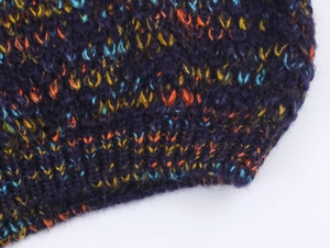 Detailed macro texture of a thick purple knitted sweater with colorful mixed yarn