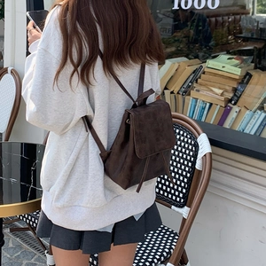 Vista posteriore a 45 gradi di un mini zaino vintage in pelle marrone su modella
