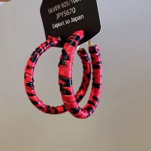Detailed close-up of 925 silver hoop earrings featuring red and black tiger pattern design