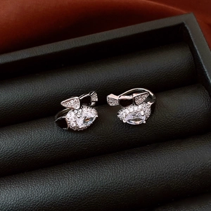 Macro detail of silver Kuromi snake earring with zircon stones in luxury jewelry box