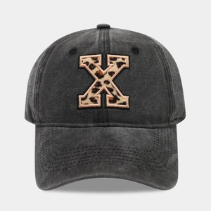 Detail of vintage washed charcoal baseball cap featuring leopard print letter X embroidery