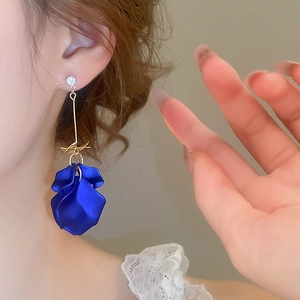 Close-up of royal blue flower petal tassel earring with zircon stud on a female model