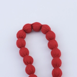 Collier de perles enveloppé de tissu rouge avec texture textile pour look de plage