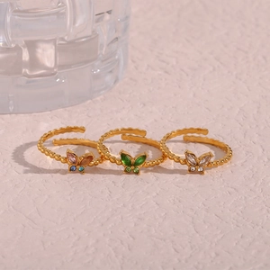 Detailansicht von drei verstellbaren Schmetterlingsringen in Gold mit bunten Steinen