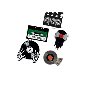 Retro cartoon enamel pins set featuring cinema clapperboard, cassette tape and vinyl record