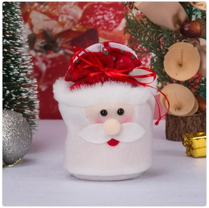 Close-up of a Santa Claus themed Christmas gift bag and candy jar with plush fabric texture