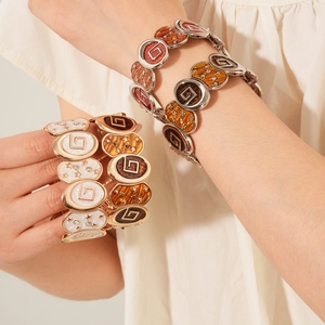 Détail macro de bracelets vintage en émail avec étoiles, zircons et motifs G