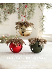 Close-up of decorative Christmas bells with pine needles, red berries and star cutouts