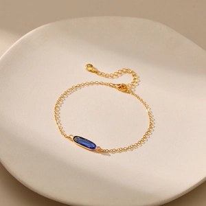 Dettaglio di una catena placcata oro 18K con pietra ovale in vetro verde smeraldo