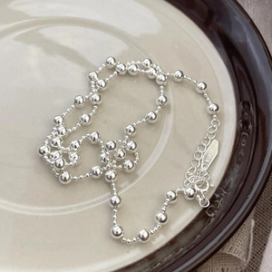 Minimalist 925 sterling silver bead necklace displayed on a ceramic plate setup