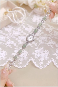 Detailed view of women's vintage bracelet watch with green jade stones and silver metal