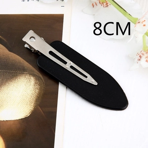 Detail view of an 8cm matte black acetate hair clip with a silver metal mechanism