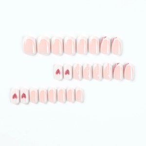 French tip press-on nails with pink glitter hearts and white droplet design