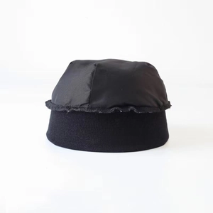 Detail of a black hip-hop cap showing the nylon top and knitted ribbed texture