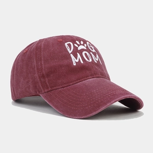 Close-up of wine red washed cotton baseball cap with white DOG MOM embroidery and paw print