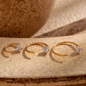 Three gold G23 titanium C-shaped nose rings with sparkling zircons in graduated sizes