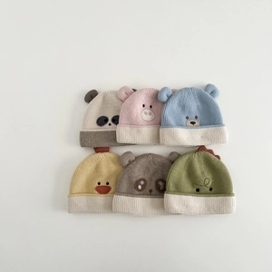 Flat lay of colorful baby knit hats featuring cute embroidered animal faces and 3D ears