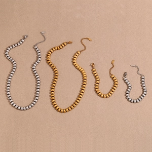 Flat lay of gold and silver bean link necklaces and bracelets with lobster clasps